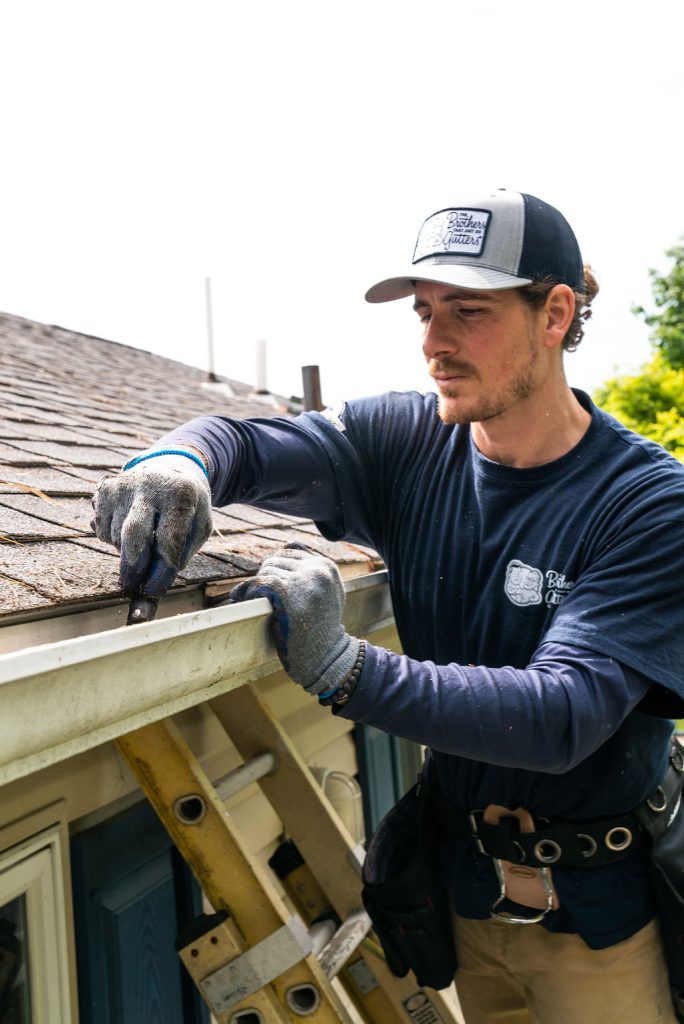 gutter contractors - technician cleaning gutters