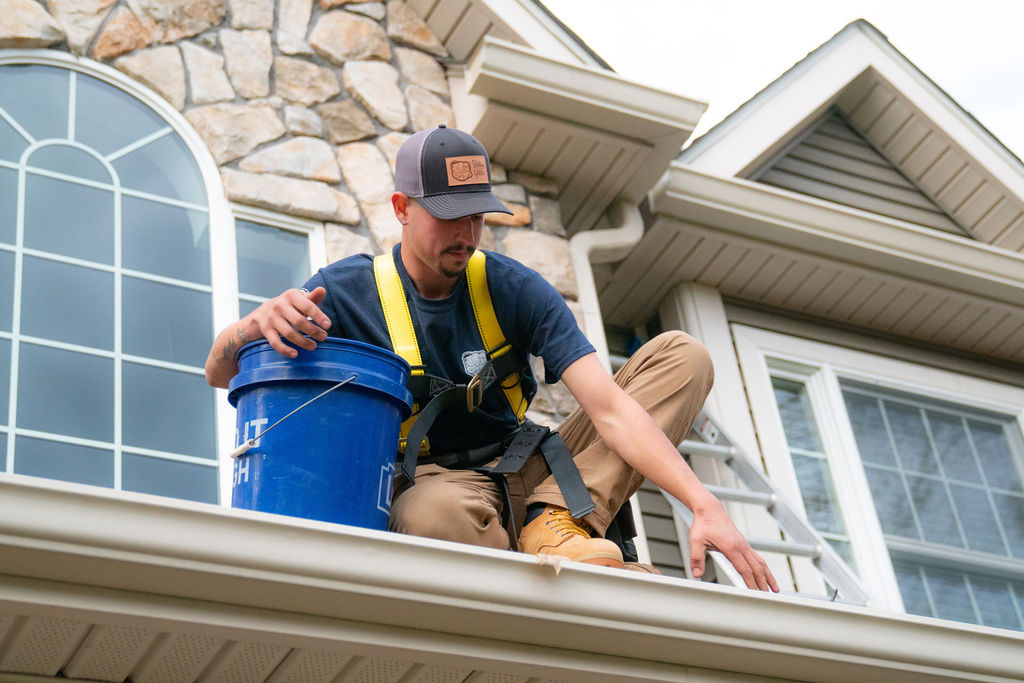 gutter services - gutter cleaning tech working on a gutter