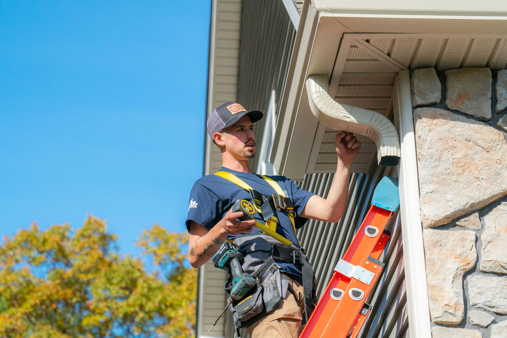 gutter services - gutter repair tech on ladder