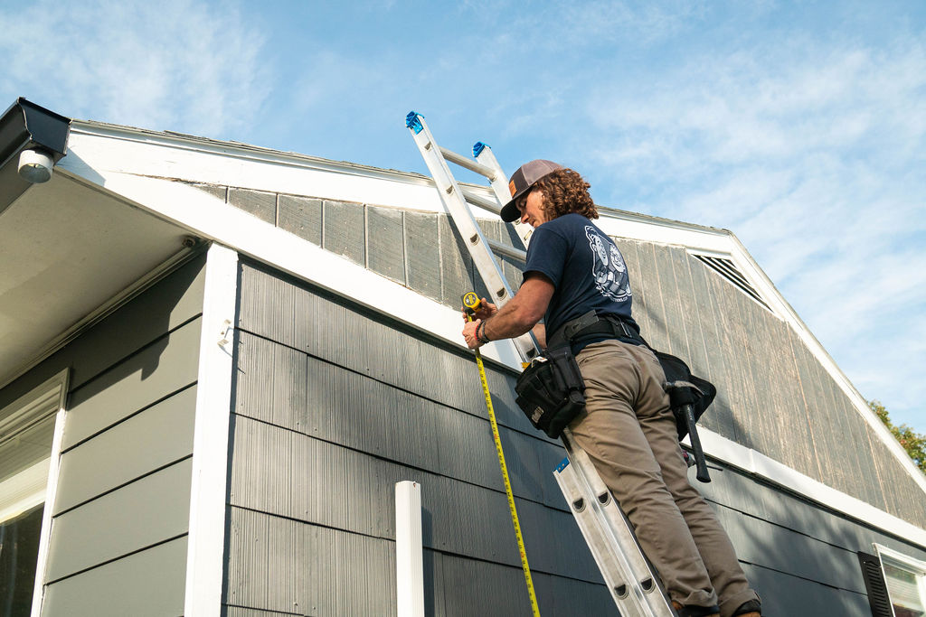 gutter installation tech working on a ladder