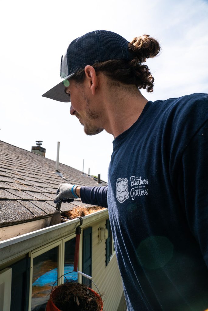 gutter cleaning technician cleaning a gutter