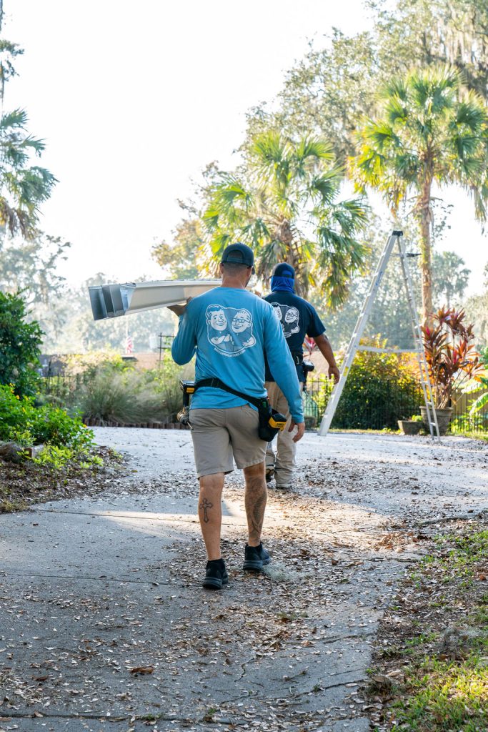 gutter installation techs carrying gutters